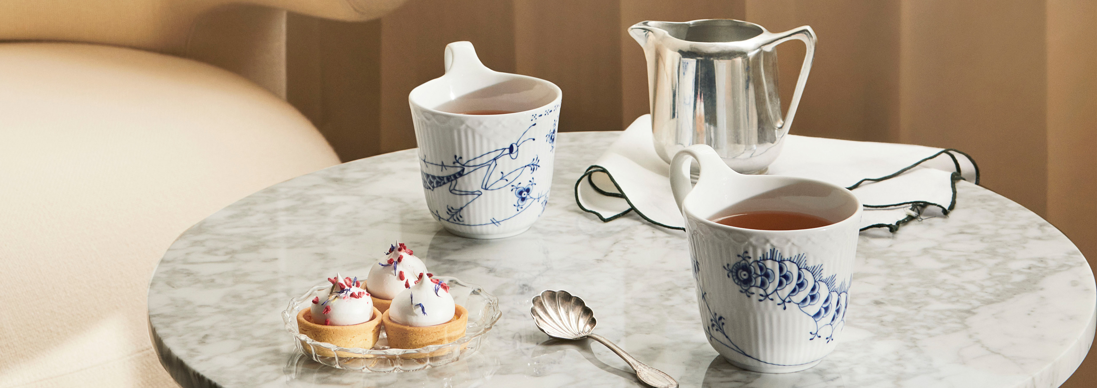 Marmorbord med to højhankskopper i Royal Creatures fra Royal Copenhagen